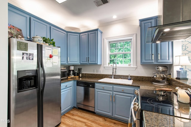 116 Northbrook Dr Unit 303, Raleigh, NC 27609 - kitchen featuring appliances with stainless steel finishes, blue cabinets, wall chimney range hood, and ornamental molding