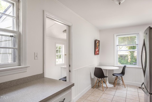 2331 Stevens Rd, Raleigh, NC 27610 - dining area featuring light tile patterned floors, a wainscoted wall, and ornamental molding