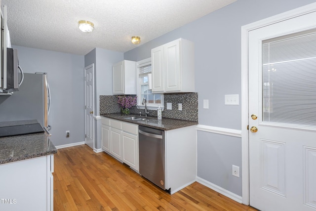 637 Convexa Ct, Wendell, NC 27591 - kitchen with appliances with stainless steel finishes, light wood-style flooring, white cabinets, and a textured ceiling