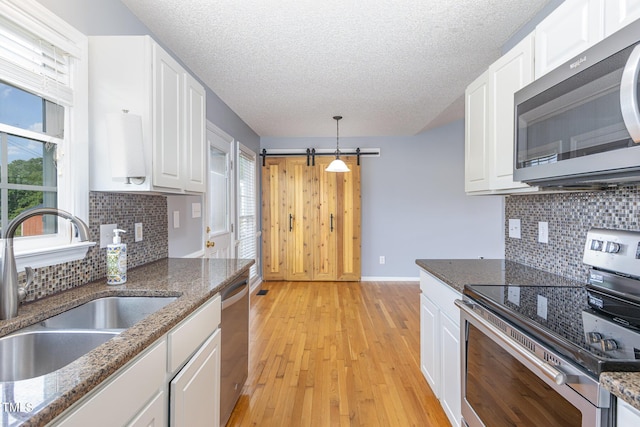 637 Convexa Ct, Wendell, NC 27591 - kitchen featuring stainless steel appliances, white cabinetry, light wood-style flooring, tasteful backsplash, and a textured ceiling