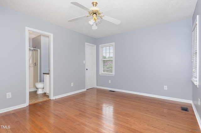 637 Convexa Ct, Wendell, NC 27591 - unfurnished bedroom featuring wood finished floors, ensuite bathroom, ceiling fan, and a textured ceiling