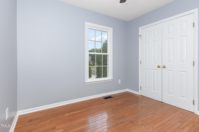 637 Convexa Ct, Wendell, NC 27591 - unfurnished bedroom with hardwood / wood-style floors, a closet, a ceiling fan, and a textured ceiling