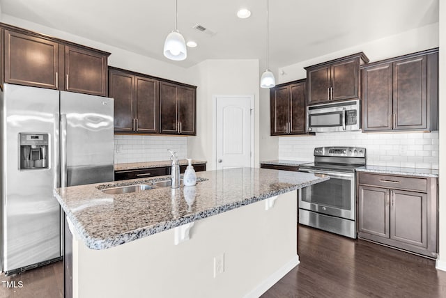 7817 Elmshire Way, Raleigh, NC 27616 - kitchen featuring appliances with stainless steel finishes, dark brown cabinets, light stone countertops, and backsplash