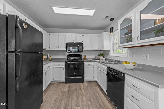 4812 Morecambe Way, Apex, NC 27539 - kitchen featuring black appliances, light wood-style floors, white cabinetry, tasteful backsplash, and a textured ceiling