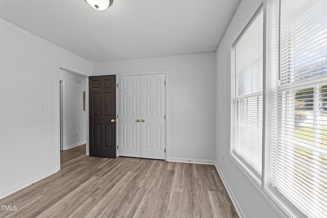 4812 Morecambe Way, Apex, NC 27539 - unfurnished bedroom featuring light wood-style flooring, a closet, and a textured ceiling
