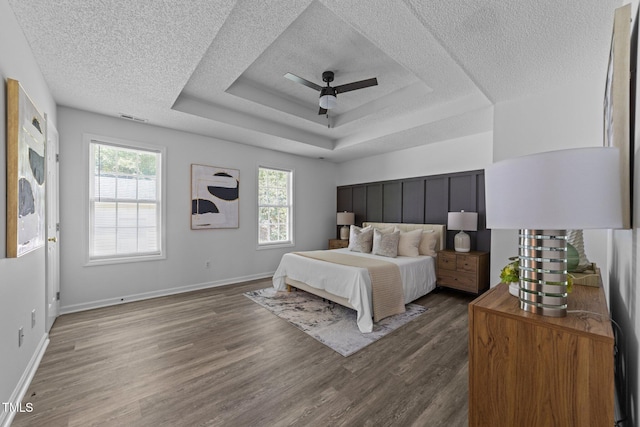 4812 Morecambe Way, Apex, NC 27539 - bedroom featuring a textured ceiling, dark wood-style floors, a ceiling fan, and a tray ceiling