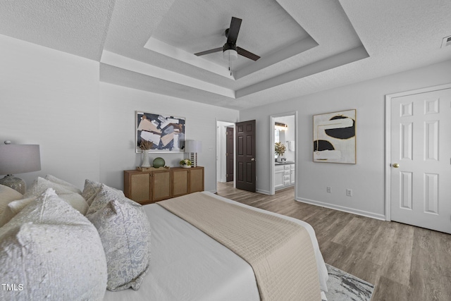 4812 Morecambe Way, Apex, NC 27539 - bedroom with wood finished floors, a tray ceiling, a ceiling fan, a textured ceiling, and ensuite bath