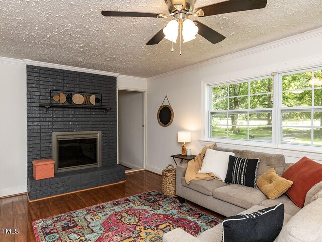 1831 Washington Dr, Hillsborough, NC 27278 - living area featuring wood finished floors, a textured ceiling, a fireplace, crown molding, and a ceiling fan
