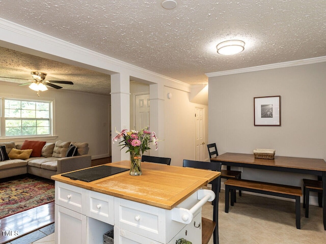 1831 Washington Dr, Hillsborough, NC 27278 - kitchen with a textured ceiling, light tile patterned flooring, white cabinetry, ornamental molding, and black electric cooktop