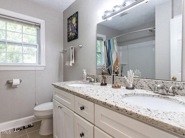 1831 Washington Dr, Hillsborough, NC 27278 - bathroom featuring a textured ceiling, tile patterned floors, double vanity, and a shower with curtain