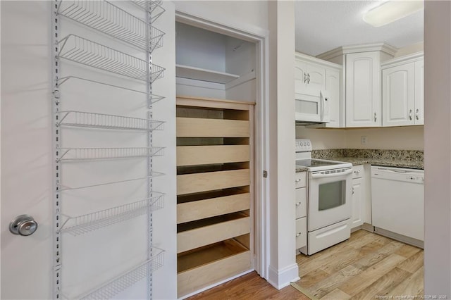 1100 Clarendon St Unit 303, Fayetteville, NC 28305 - kitchen featuring white appliances, light wood-type flooring, white cabinetry, and stone countertops