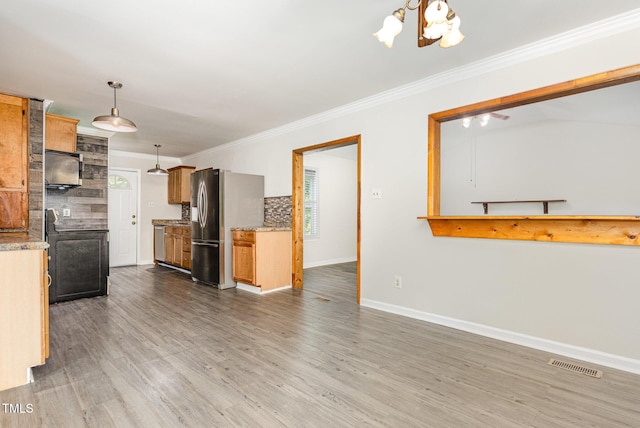5807 Craig Rd, Durham, NC 27712 - kitchen with stainless steel fridge, ornamental molding, tasteful backsplash, a chandelier, and wood finished floors