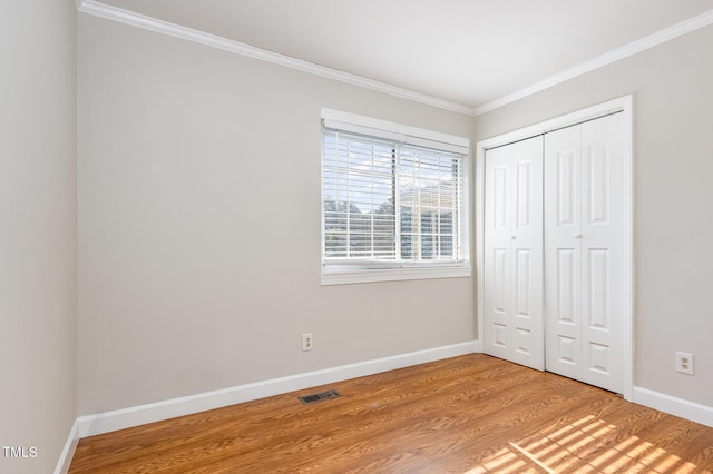 5807 Craig Rd, Durham, NC 27712 - unfurnished bedroom featuring crown molding, a closet, and light wood-style floors