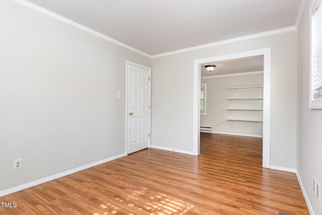 5807 Craig Rd, Durham, NC 27712 - spare room with baseboard heating, light wood-style flooring, ornamental molding, and built in features