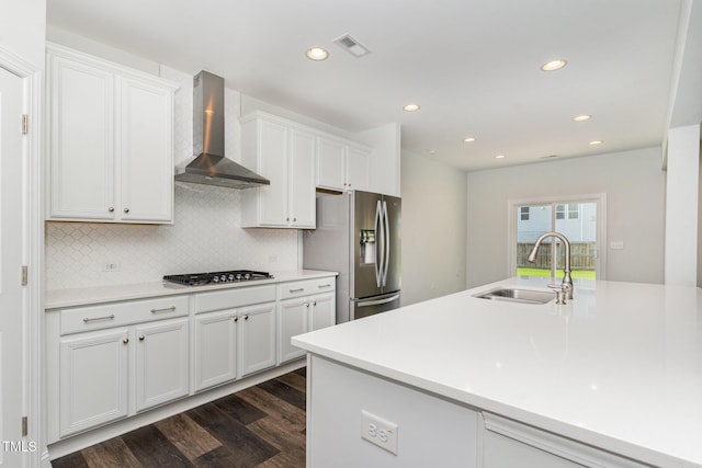 3409 Table Mountain Pine Dr, Raleigh, NC 27616 - kitchen with stainless steel fridge, wall chimney range hood, dark wood finished floors, gas cooktop, and white cabinets