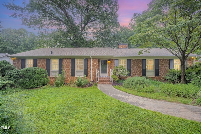 2425 Wentworth St, Raleigh, NC 27612 - single story home featuring a front yard, a chimney, and brick siding