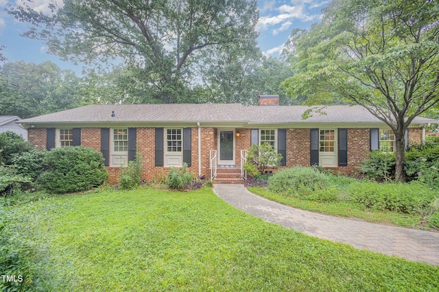 2425 Wentworth St, Raleigh, NC 27612 - ranch-style home featuring a front lawn, brick siding, a chimney, and a shingled roof