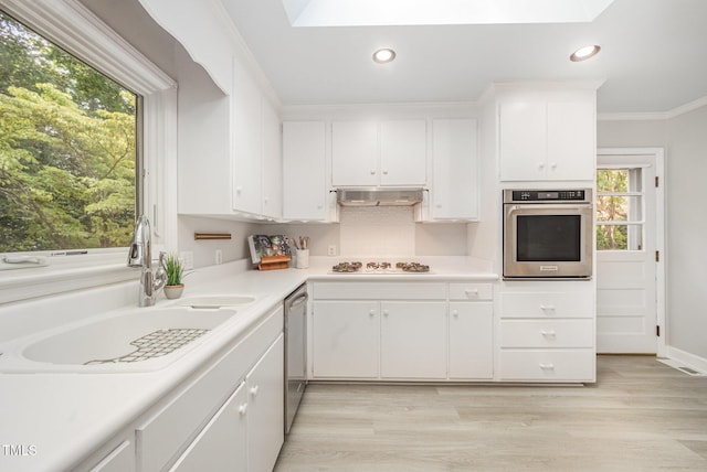 2425 Wentworth St, Raleigh, NC 27612 - kitchen featuring appliances with stainless steel finishes, light countertops, white cabinetry, crown molding, and recessed lighting
