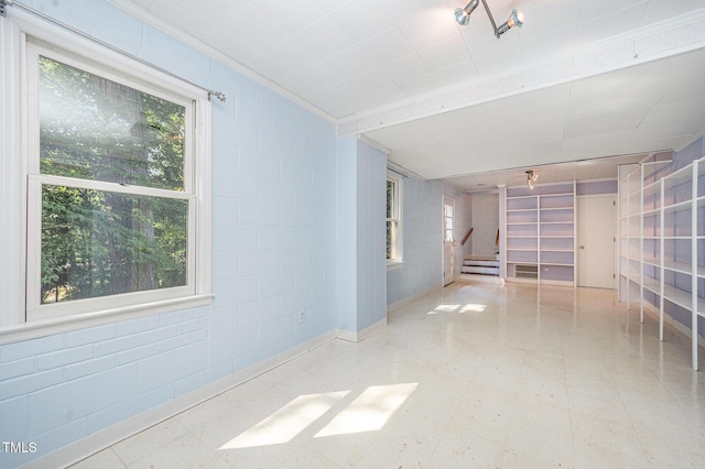 2425 Wentworth St, Raleigh, NC 27612 - empty room with stairway, a baseboard heating unit, tile patterned floors, and concrete block wall