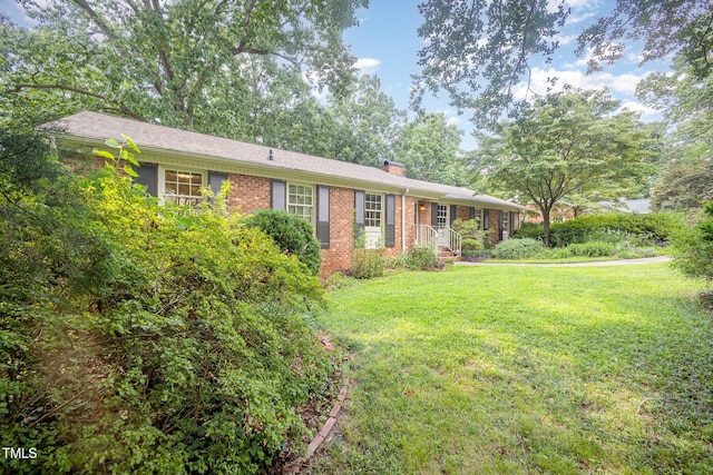 2425 Wentworth St, Raleigh, NC 27612 - ranch-style house with brick siding, a front lawn, and a chimney