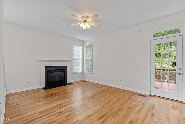1401 Patterson Grove Rd, Apex, NC 27502 - unfurnished living room with light wood-style floors, a ceiling fan, and a fireplace with flush hearth