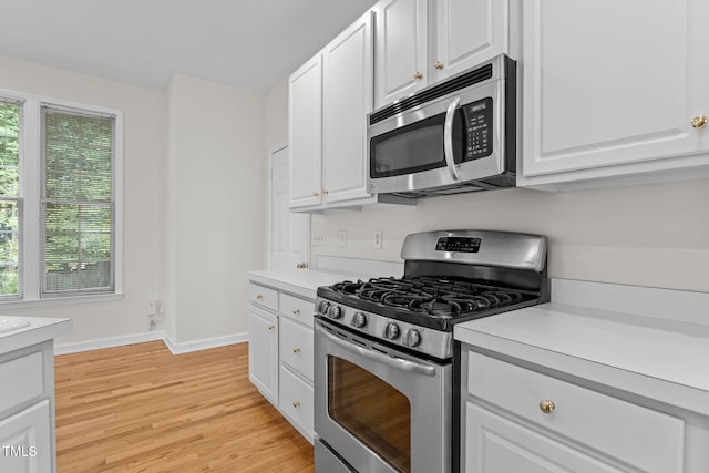 1401 Patterson Grove Rd, Apex, NC 27502 - kitchen with stainless steel appliances, light wood finished floors, light countertops, and white cabinets