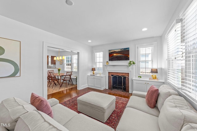 1116 E Martin St, Raleigh, NC 27610 - living area with wood finished floors, plenty of natural light, a chandelier, recessed lighting, and a brick fireplace
