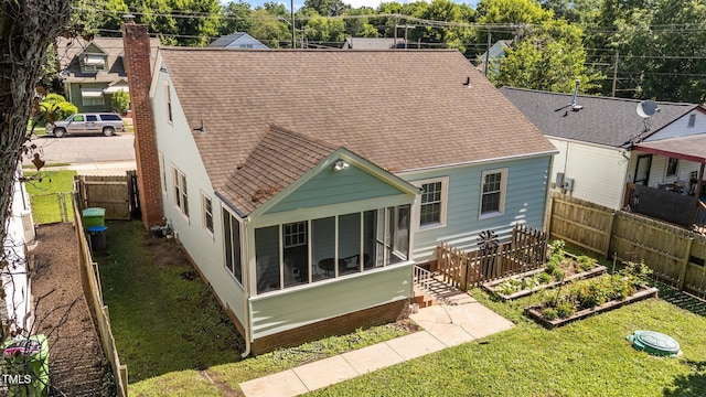 1116 E Martin St, Raleigh, NC 27610 - rear view of property featuring roof with shingles, a garden, a chimney, and a sunroom