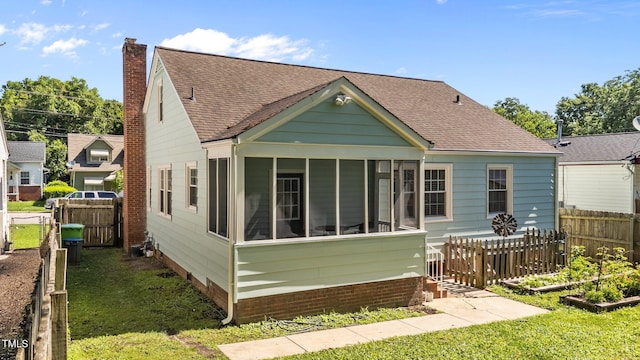 1116 E Martin St, Raleigh, NC 27610 - back of house featuring a sunroom, a chimney, and roof with shingles