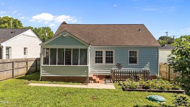 1116 E Martin St, Raleigh, NC 27610 - back of house with a sunroom, a fenced backyard, a shingled roof, and a garden