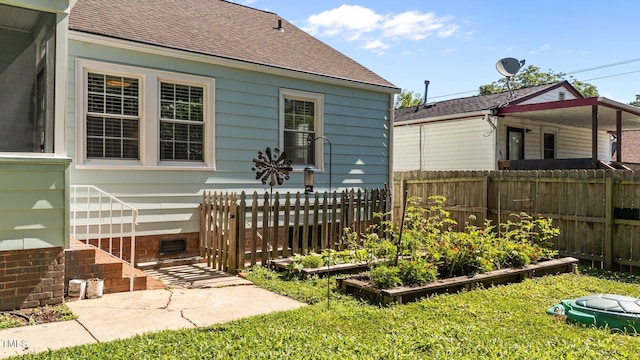 1116 E Martin St, Raleigh, NC 27610 - rear view of house featuring roof with shingles and a vegetable garden