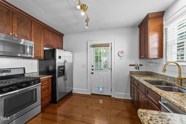 1116 E Martin St, Raleigh, NC 27610 - kitchen featuring appliances with stainless steel finishes, dark wood-type flooring, light stone counters, and track lighting
