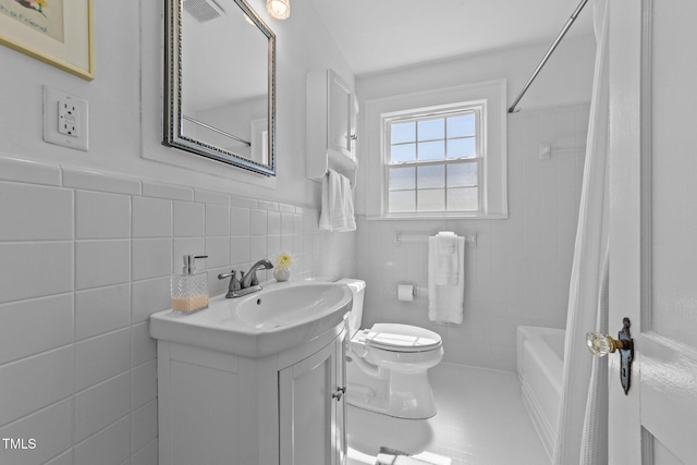 1116 E Martin St, Raleigh, NC 27610 - bathroom featuring vanity, tile walls, shower / tub combo with curtain, and wainscoting