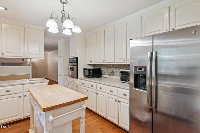 410 Sherron Rd, Durham, NC 27703 - kitchen with appliances with stainless steel finishes, butcher block counters, backsplash, decorative light fixtures, and light wood-style floors