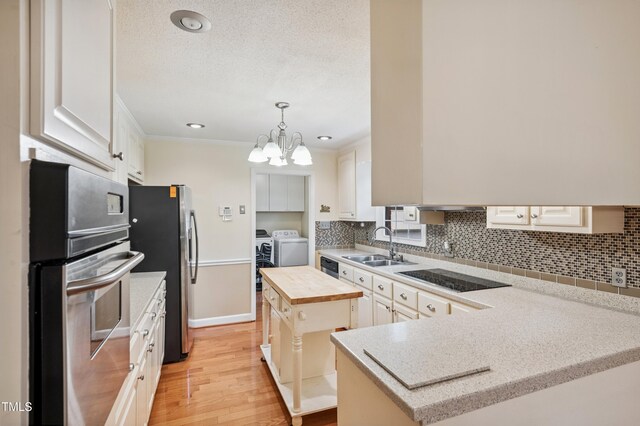 410 Sherron Rd, Durham, NC 27703 - kitchen featuring appliances with stainless steel finishes, separate washer and dryer, wooden counters, decorative backsplash, and light wood-style flooring
