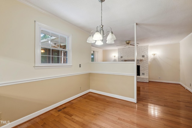 410 Sherron Rd, Durham, NC 27703 - unfurnished dining area featuring ornamental molding, wood finished floors, ceiling fan, a fireplace, and a chandelier