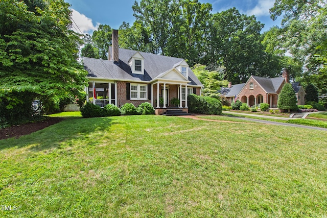 2328 Byrd St, Raleigh, NC 27608 - new england style home with brick siding, a chimney, a front yard, and a porch