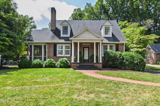 2328 Byrd St, Raleigh, NC 27608 - cape cod house with brick siding, a front yard, a chimney, and a sunroom