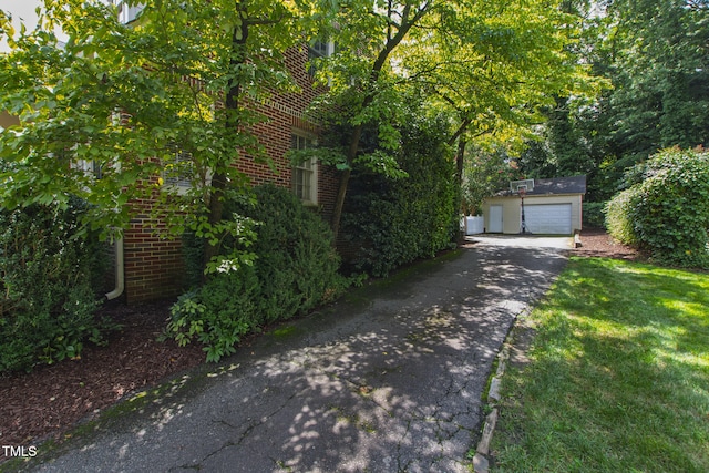 2328 Byrd St, Raleigh, NC 27608 - view of front of house with an outdoor structure, brick siding, a detached garage, and asphalt driveway