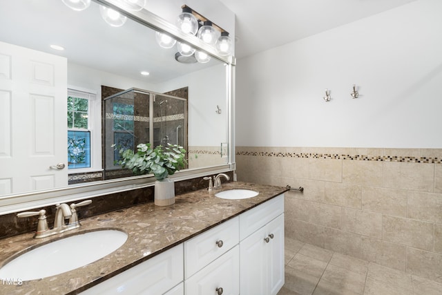 102 Glenmore Rd, Cary, NC 27519 - bathroom featuring a stall shower, double vanity, tile walls, and wainscoting