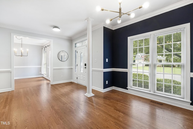 102 Glenmore Rd, Cary, NC 27519 - entrance foyer featuring a chandelier, crown molding, wood finished floors, and ornate columns