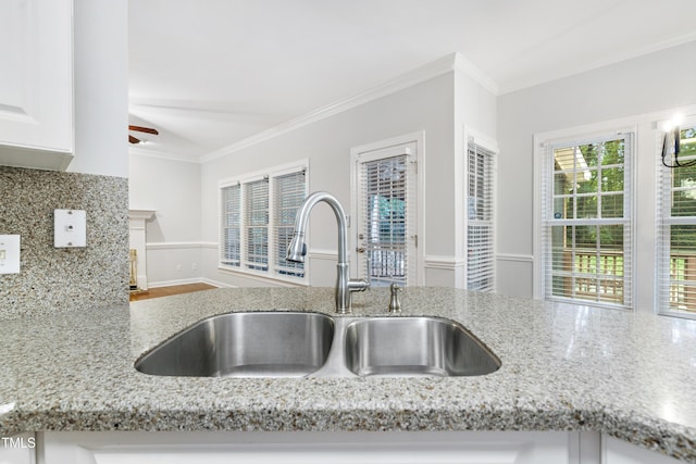 102 Glenmore Rd, Cary, NC 27519 - kitchen featuring crown molding, light stone countertops, white cabinets, a ceiling fan, and a fireplace