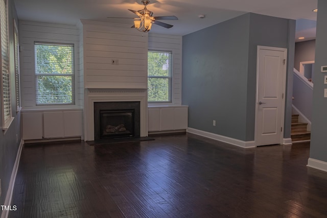 4921 Sweet Shade Trl, Raleigh, NC 27616 - unfurnished living room featuring a ceiling fan, dark wood-style flooring, stairs, and a fireplace