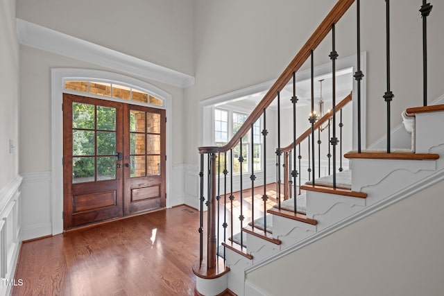 3005 Canopy Woods Dr, Apex, NC 27539 - foyer with french doors, stairway, wainscoting, wood finished floors, and a decorative wall