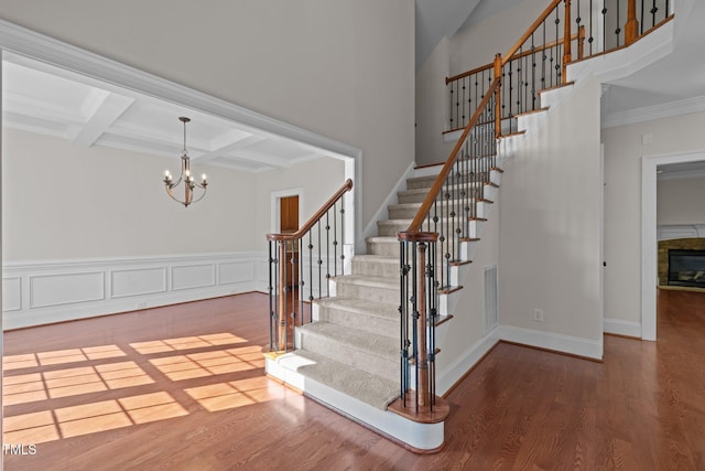 3005 Canopy Woods Dr, Apex, NC 27539 - stairs with wood finished floors, coffered ceiling, a chandelier, beam ceiling, and ornamental molding