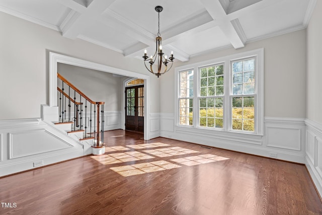 3005 Canopy Woods Dr, Apex, NC 27539 - unfurnished dining area featuring coffered ceiling, a chandelier, stairway, wood finished floors, and wainscoting
