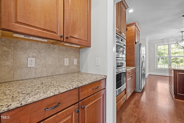 3005 Canopy Woods Dr, Apex, NC 27539 - kitchen featuring dark wood finished floors, brown cabinetry, light stone countertops, crown molding, and recessed lighting