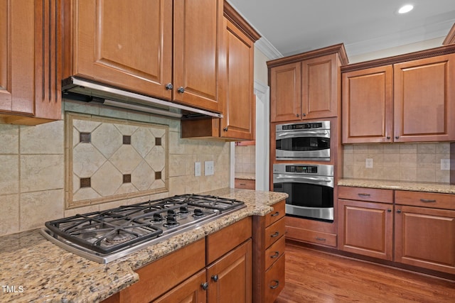 3005 Canopy Woods Dr, Apex, NC 27539 - kitchen with appliances with stainless steel finishes, backsplash, brown cabinets, recessed lighting, and crown molding