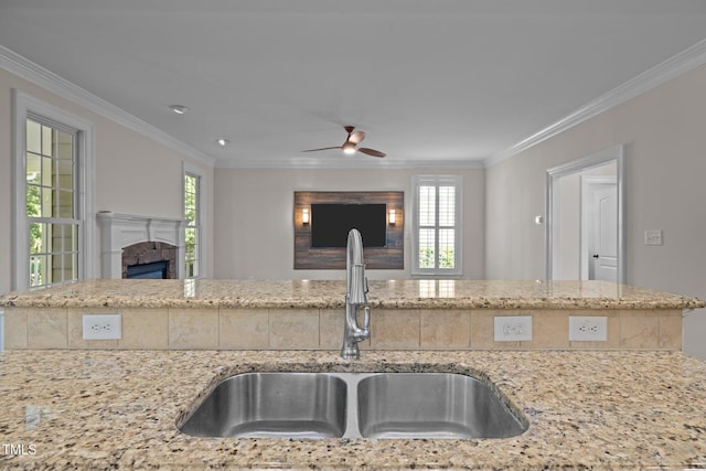 3005 Canopy Woods Dr, Apex, NC 27539 - kitchen featuring a fireplace, ornamental molding, ceiling fan, light stone counters, and open floor plan