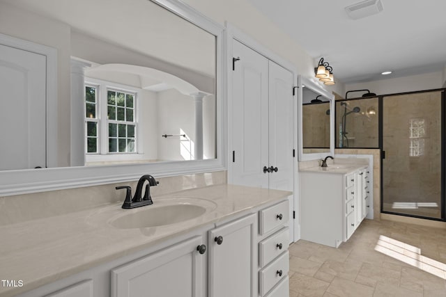 3005 Canopy Woods Dr, Apex, NC 27539 - bathroom featuring two vanities, a shower stall, decorative columns, and stone finish flooring